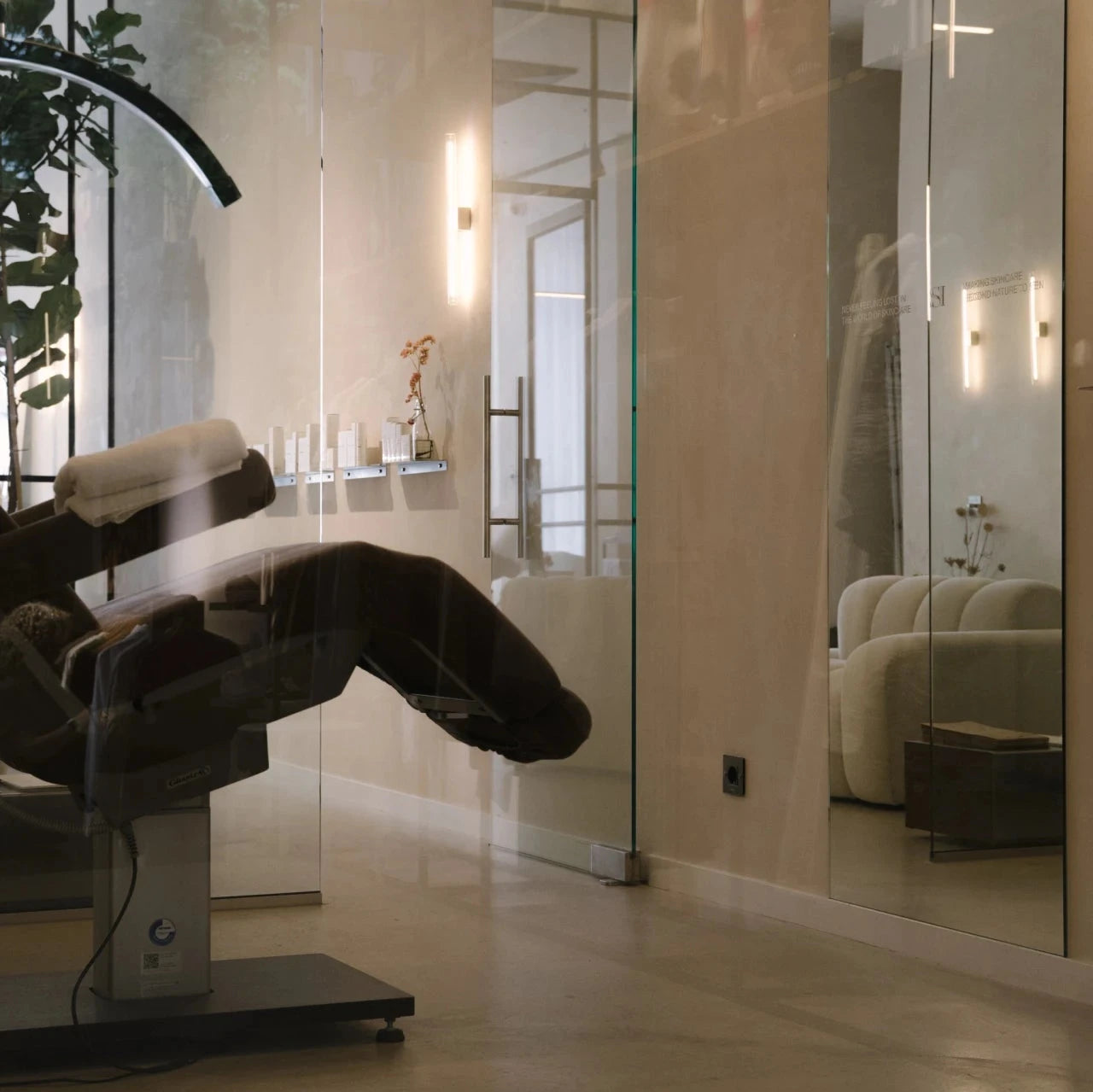 Modern treatment room at Salon d’Homme in Amsterdam, featuring a comfortable chair, glass walls, and a serene atmosphere.